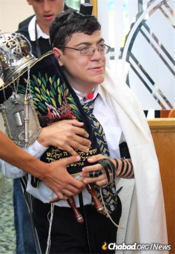 Proudly carrying the Torah scroll at his 2013 bar mitzvah celebration.
