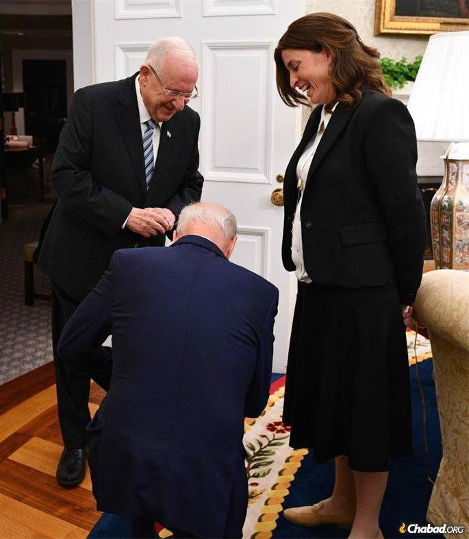 U.S. President Joe Biden kneels before Rivka Ravitz, Israeli President Reuven Rivlin&#39;s chief of staff, after learning that she has 12 children. (Photo: Haim Zach/Israel GPO)