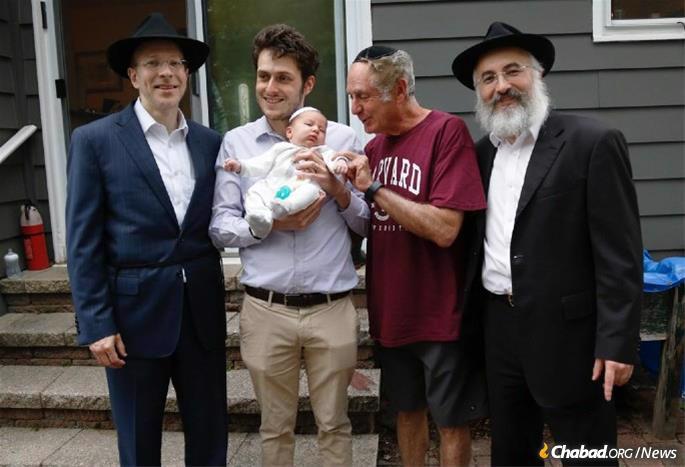 Newborn Zev Mordechai Mandler, center, with his father, Michael Mandler and (at right) grandfather Raul Mandler, who all took part in “pidyon haben” ceremonies conducted by Rabbi Aryeh Weinstein, left, a kohen, and Rabbi Yitzchak Goldenberg, spiritual leader of the Young Israel of Lawrenceville, N.J., and co-director of Chabad of Lawrenceville.
