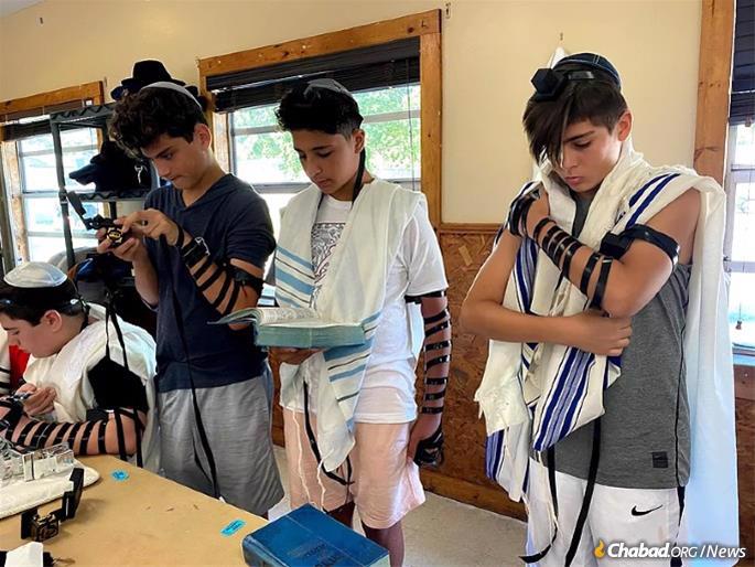 Older campers don tefillin during morning services.