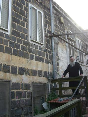 Rabbi Chaim Baruch Halberstam stands by the house that was across from his childhood home.