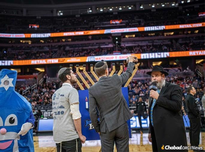 Chabad representatives of Greater Orlando look on as the menorah is lit during an intermission.