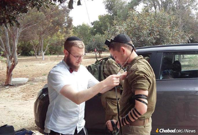 Kay assists a soldier with tefillin.