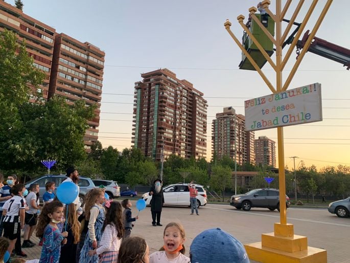 El Rabino Menashe Perman junto al rabino Ishai Liberson rodeados de niños en el evento central de Santiago