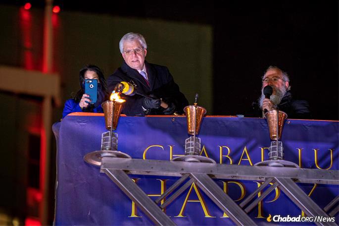 Community leader Gary Torgo kindles the first light of Chanukah. (Photo: James Feldman Photography)