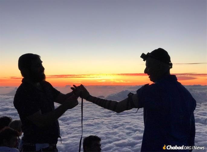 Haleakalā is a place for mitzvahs, and not just on Chanukah. Here, Rabbi Mendy Krasnjansky helps a visitor with a last-minute chance to put on tefillin before nightfall.