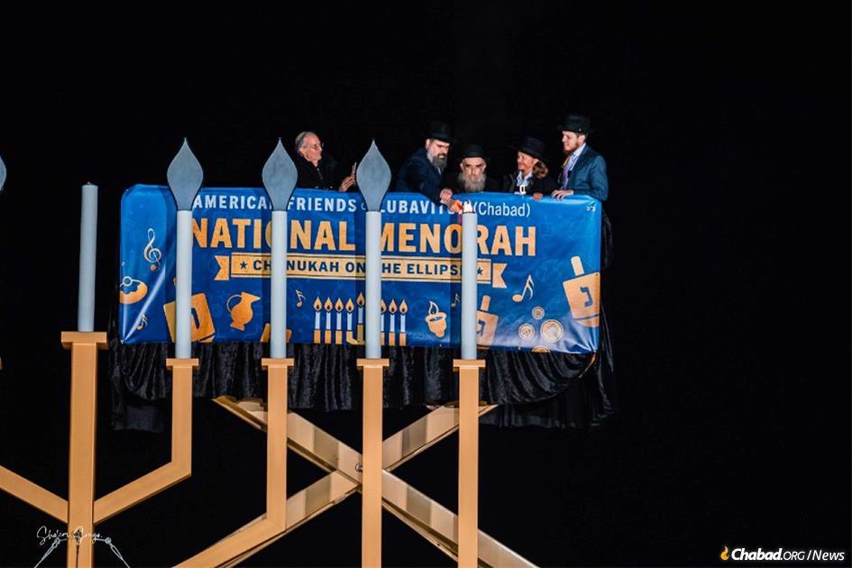 Rabbis Abraham Shemtov and Levi Shemtov light the National Menorah, accompanied by philanthropist Louis Mayberg and entrepreneur Brock Pierce. (Photo: Sholom Srugo)