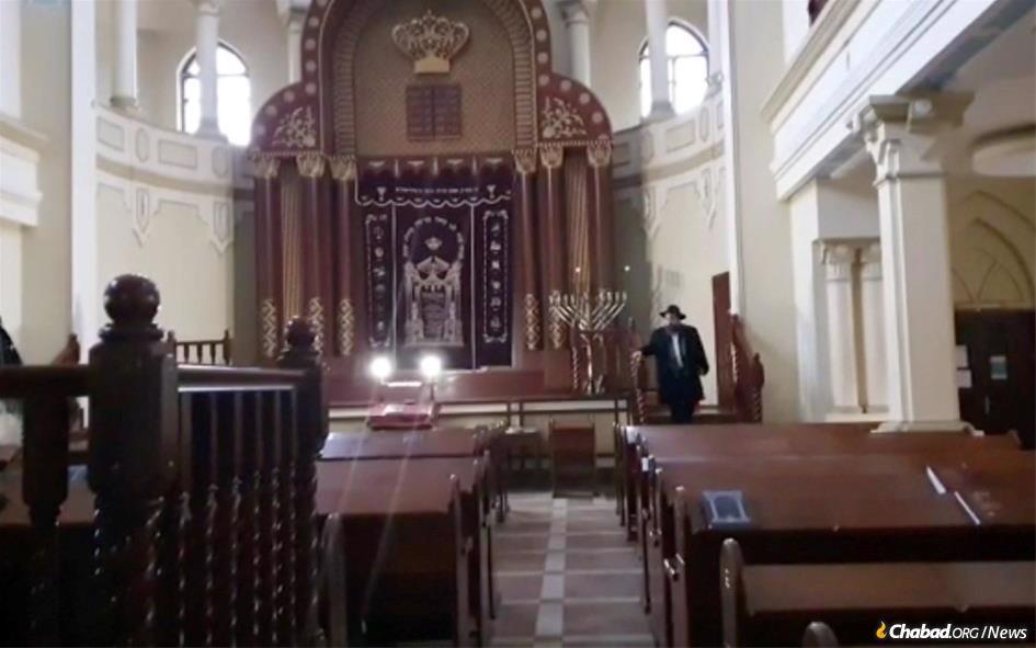 Rabbi Moshe Moskovitz, Chabad-Lubavitch emissary in Kharkov since 1990, kisses the curtain on the Holy Ark in the sanctuary as he vows to return to the city.