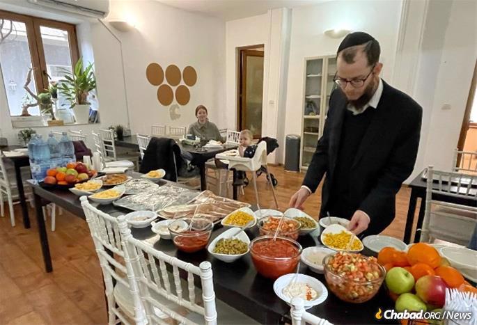 Rabbi Yitzchak Raskin prepares food for a group of refugees in Bucharest