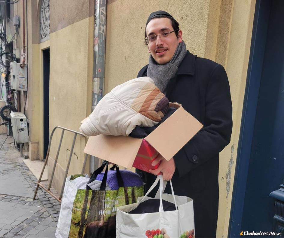 In Bucharest, Hershel Marozow is seen carrying bedding and other staples for a group of refugees.