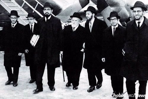 Los primeros shlujim (Avrohom Altein, Leibel Kaplan, Hirshel Lipskier, Shloma Majeski, Yosef Minkowitz y Hirshel Morozov) con el rabino Eliahu (Iaijel) Simpson, en el centro, llegando al aeropuerto de Australia.