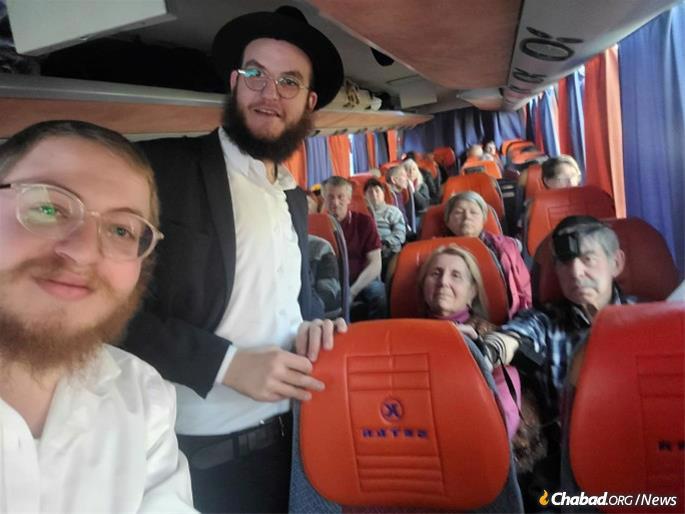 Rabbi Malkin's grandson, Gregory Rivkin (far right), puts on tefillin with Mendel Bleich and Ehrentreu on the bus heading to Poland.