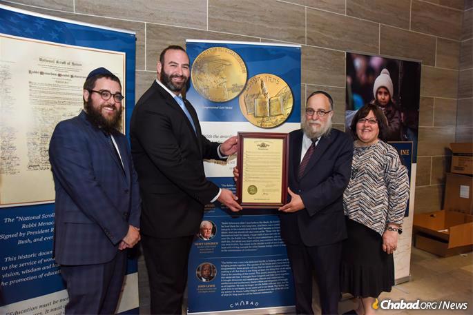 Rep. Adam Schwadron (second from left) presents a House Resolution honoring the Rebbe to (l-r) Rabbi Chaim Landa, of St. Charles County, Mo and Rabbi Yosef Landa and Mrs. Shiffy Landa, of St. Louis County, Mo