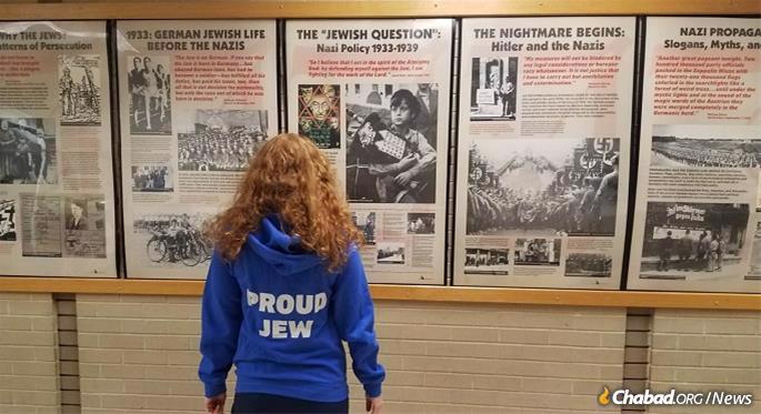 A member of the Jewish Students Association admires an educational display that the group arranged, provided by the Simon Wiesenthal Center.