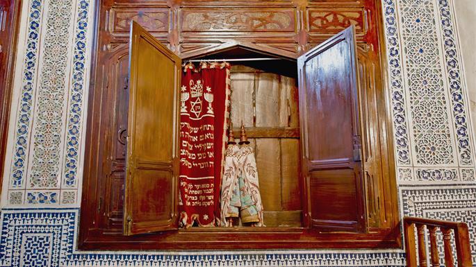 Este rolo de Tor&#225;, visto na Sinagoga Aben Danan em Fez, &#233; coberto com tecido, n&#227;o em um estojo r&#237;gido. Isso segue a tradi&#231;&#227;o espanhola, ao contr&#225;rio dos sefarditas orientais, que abrigam suas Torot em caixas cil&#237;ndricas.