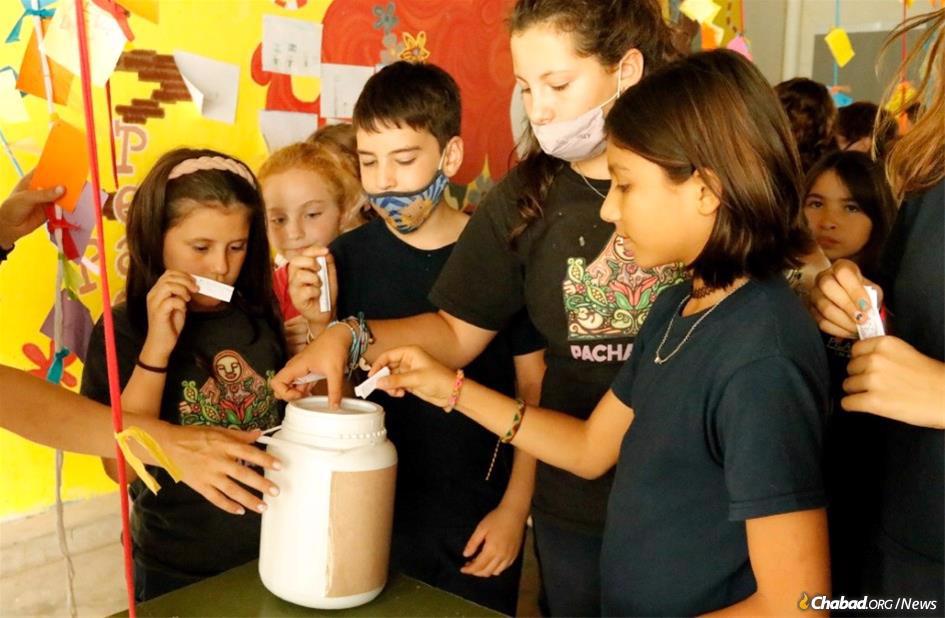 Schoolchildren in Rosario, Argentina, particpate in Chabad&#39;s “Your Action Illuminates” campaign by giving charity.