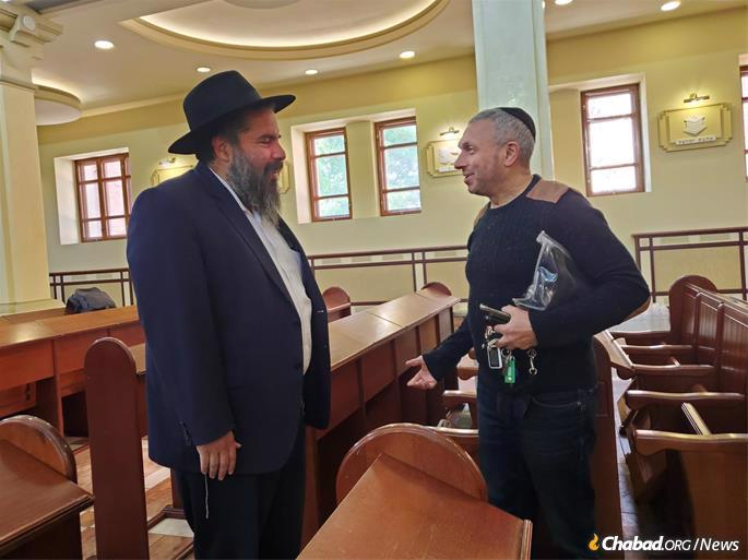 A Jewish communty member welcomes his rabbi home. The shul, which the rabbi returned to and prayed in on Tuesday, continues to house people in its basement, while minyanim (prayer services) continue, as they always have, in the sanctuary.