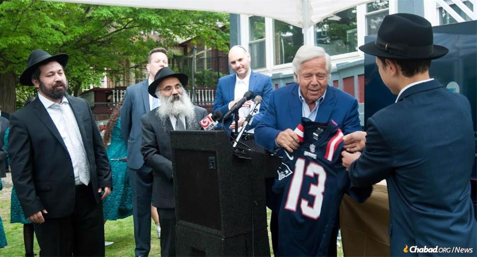 A year ago, Rabbi Shlomo Noginski, left, was stabbed eight times by a terrorist, and in response, pledged to open a yeshivah In New England to educate an initial cohort of eight rabbis. Last week, philanthropist Robert Kraft, second from right, inaugurated the new program, as Rabbi Dan Rodkin, second from left, director of Shaloh House, a Chabad-affiliated school and Jewish community center in the Boston area, and other donors looked on. (Credit: Olga Mariotti)