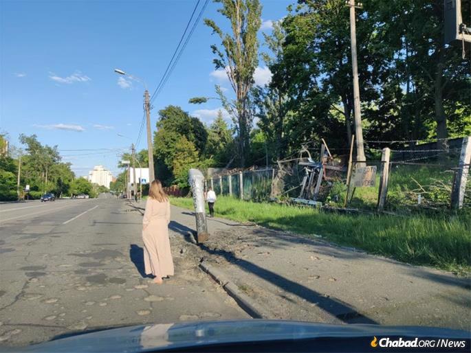 Devorah Levenharts stands silently near a bomb that lodged itself in the road outside of Babi Yar, where as many as 150,000 victims—including her own great-great-grandmother—were murdered.