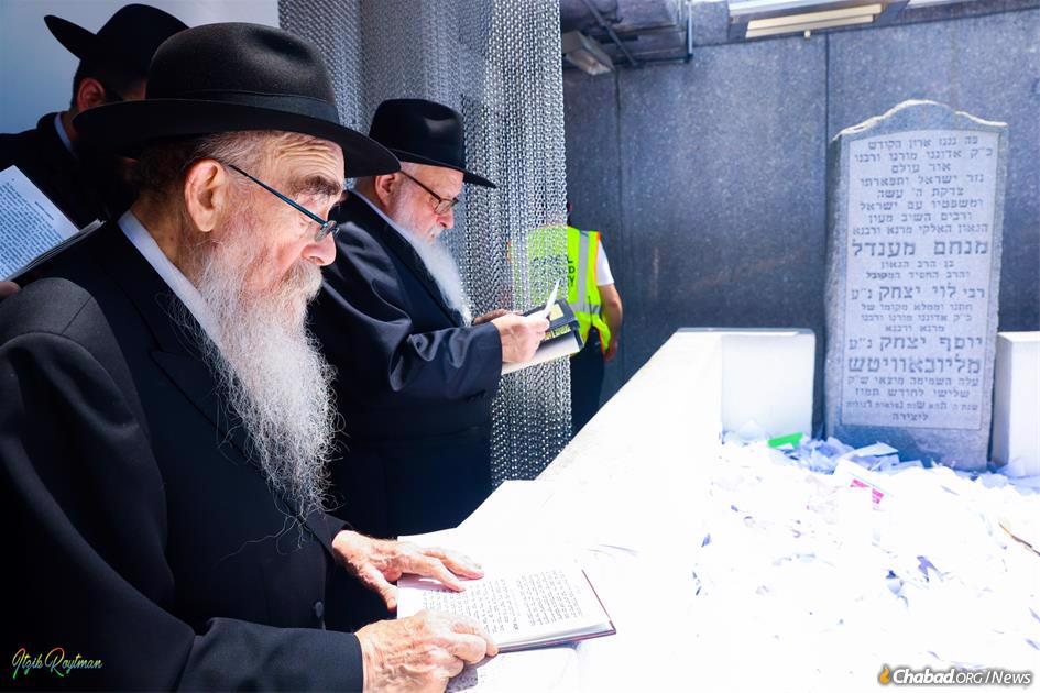 On Friday afternoon, the “pan klali” (general letter), which was signed by many Chassidim from around the world, was read at the Ohel by Rabbi Abraham Shemtov, left. (Photo: Itzik Roitman)