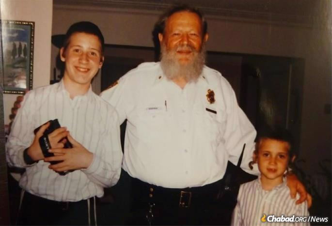 In his police uniform, posing with two of his many grandchildren.