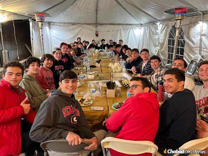 Students at a “Grill the Rabbi” session at Chabad’s outdoor tent.