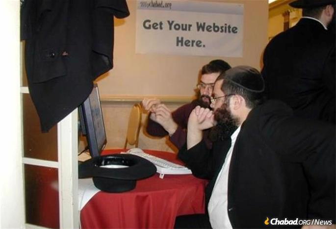 Rabbi Moshe Rosenberg, director of ChabadOne, rear center, explains the benefits of a local web site to Rabbi Yochanan Rivkin of Chabad of New Orleans in 2004. (Credit: Shmais.com)