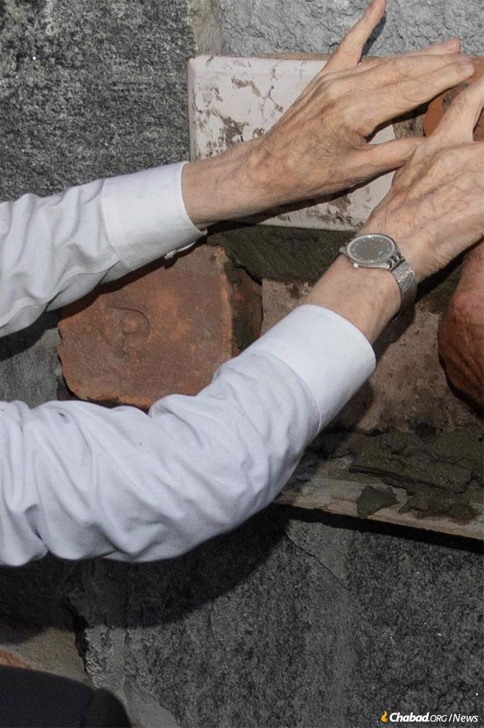 Placing a brick during the ceremony.