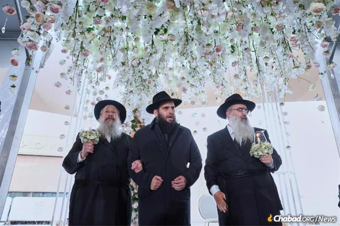 Rabbi Levi Duchman under the chuppah with his father and father-in-law (Credit: Jewish UAE / Christopher Pike)