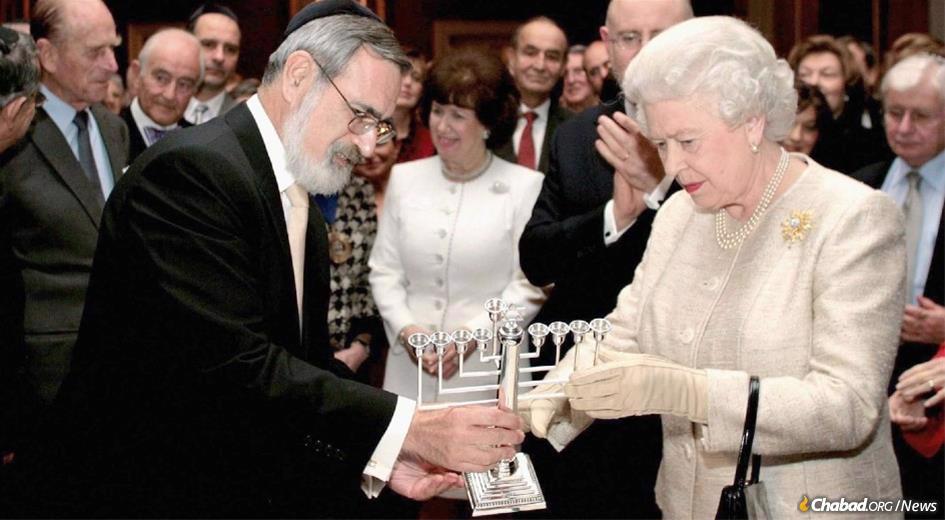 Queen Elizabeth receives a menorah from Rabbi Lord Jonathan Sacks, former Chief Rabbi of the United Kingdom, who was a longtime friend and mentor to King Charles III.