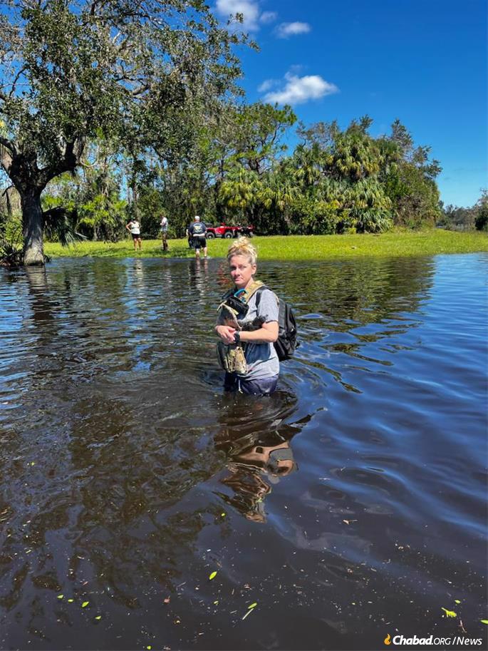 Chabad volunteer Sasha Greto wades through what had once been a Venice, Fla., street to bring aid to homebound residents.