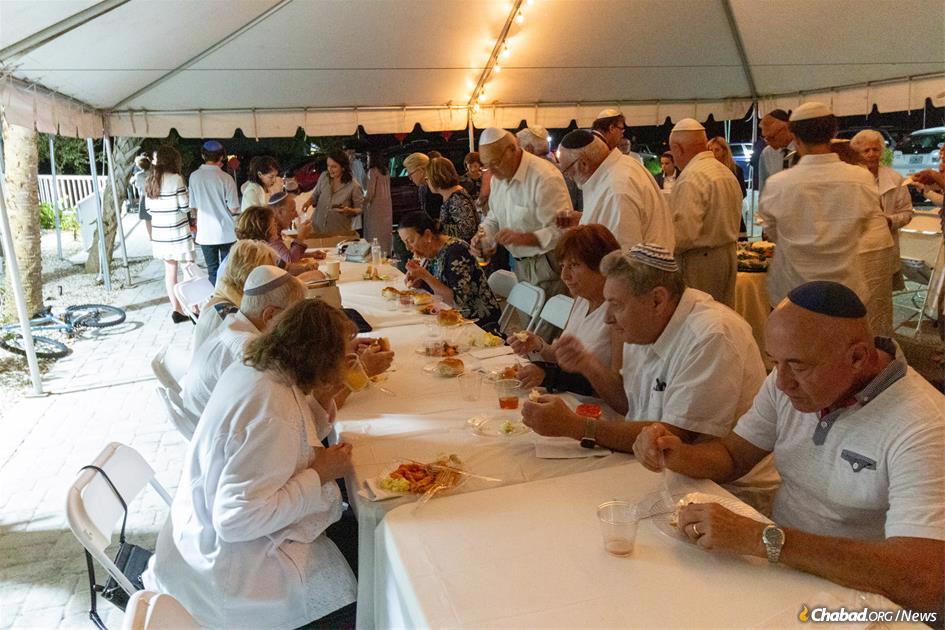 Community members gather to break the fast in a tent outside the Chabad center. (Credit: Chabad.org/Tzemach Weg)