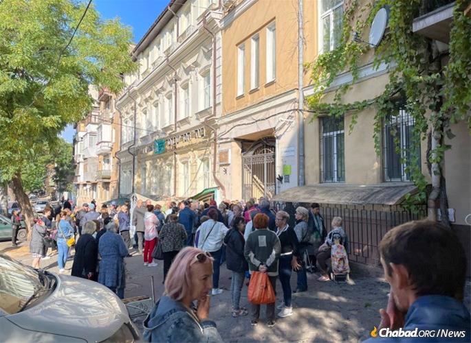 People line up in Odessa to receive food packages from Chabad