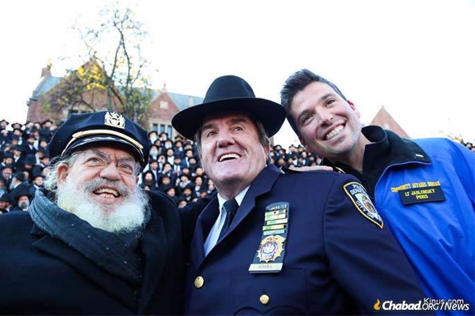 Scholl exchanges hats with Rabbi Shimon Lazaroff, regional director of Chabad-Lubavitch of Texas. It was a tradition at each year&#39;s photo shoot. They are joined by Lt. Ira Jablonsky of the New York City Police Department. (Credit: Shimi Kutner/Kinus.com)