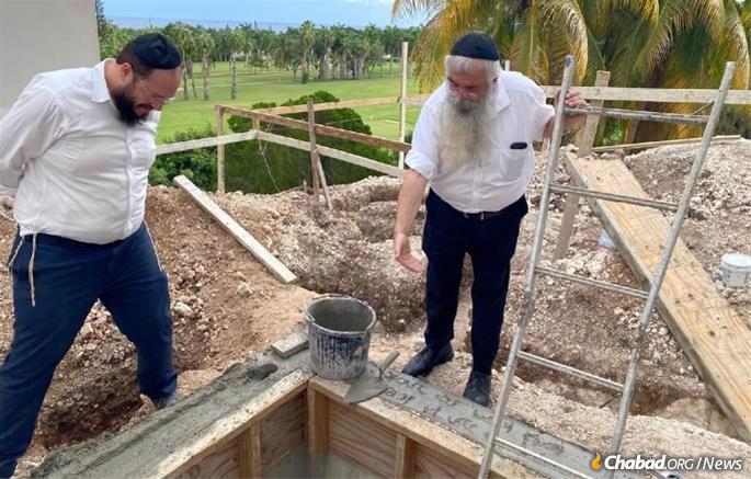 The late Rabbi Zushe Wilhelm (right) took a hands-on approach to assisting his daughter and son-in-law (left) in building Jewish life in Jamaica, including the newly completed mikvah.