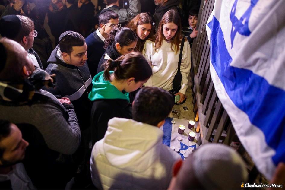 Sabato sera, persone in lutto accendono lumi nel luogo dell&#39;attacco terrorista durante il quale sette persone sono state uccise dentro e fuori una sinagoga nel quartiere Nev&#232; Ya&#39;ak&#242;v a Gerusalemme.