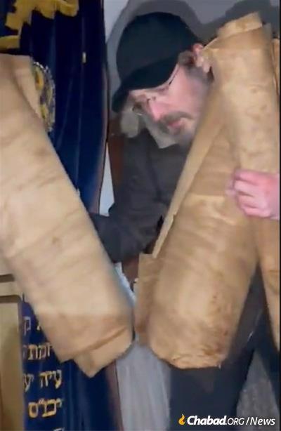 Rabbi Chitrik and community members recover historic Torah scrolls from the city&#39;s storied main synagogue.