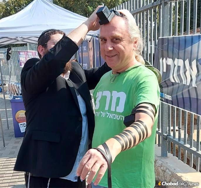 A member of the left-wing Meretz Party dons tefillin in support of Chabad’s tefillin campaign