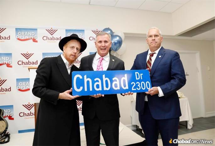 Rabbi Levi Hodakov, Robert Kasmer and Marcus Williamson with a street sign for the newly-named road adjacent to the Chabad Center—Chabad Drive.