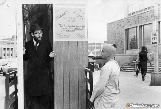 Rabbi Nosson Gurary, longtime Chabad emissary in Buffalo, N.Y., speaks with a Jewish student from the steps of his Sukkah Mobile on campus at SUNY Buffalo in the early 1970s. - Photo: Kehot Publication Society
