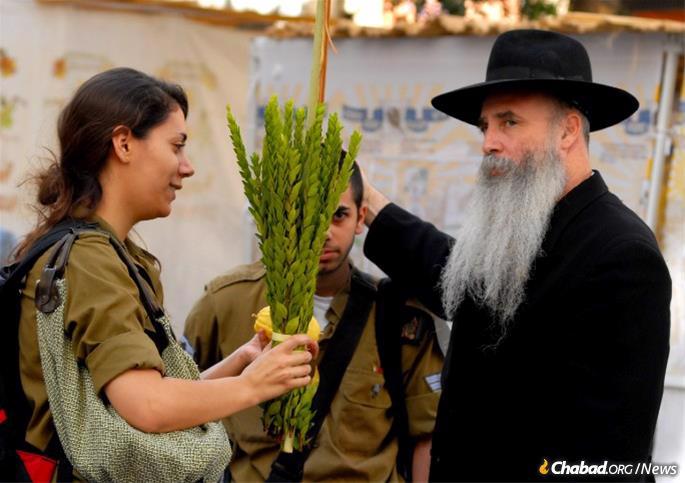 A member of the Israel Defense Forces blesses the lulav and etrog on Jerusalem&#39;s Jaffa Street in 2008. - Photo: Mark Neyman/GPO