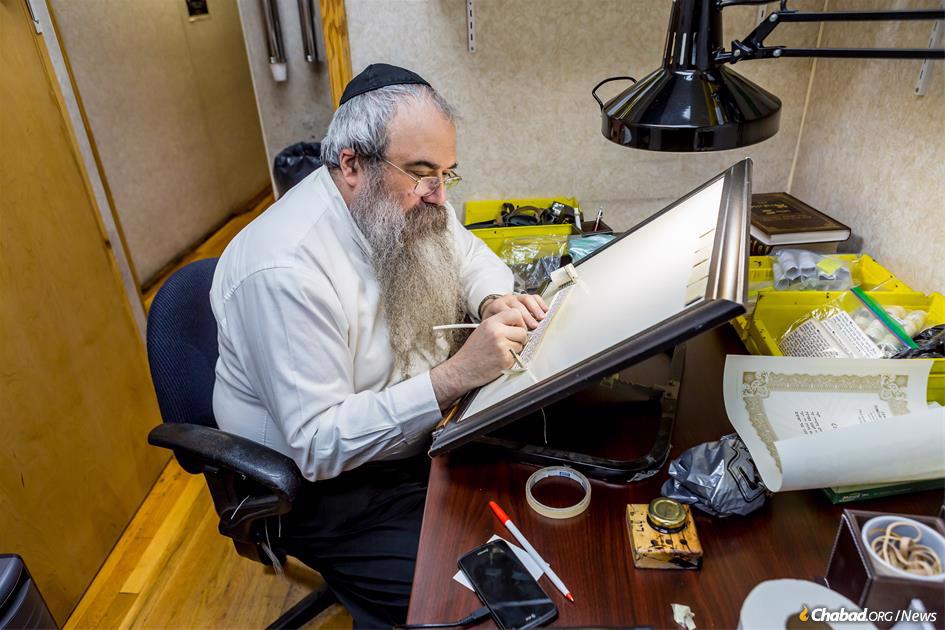 Like Torah scrolls, mezuzahs and tefillin are painstakingly handwritten by expert Jewish scribes, called sofers. Demand for the holy items has skyrocketed since the Oct. 7 terror attack in Israel, as Jews from all backgrounds seek out to do Jewish things. Scribes are scrambling to keep up with the demand. - Photo: Eliyahu Papyra/Chabad.org.