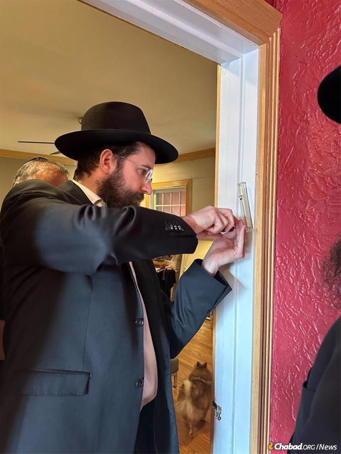 Chicago-area Chabad emissary Rabbi Zelik Moscowitz affixes a new mezuzah to the doorpost of Uri Ra’anan, father of Natalie Ra’anan, who together were her mother, Judith, was kidnapped by Hamas terrorists on Oct. 7 before being released 13 days later.