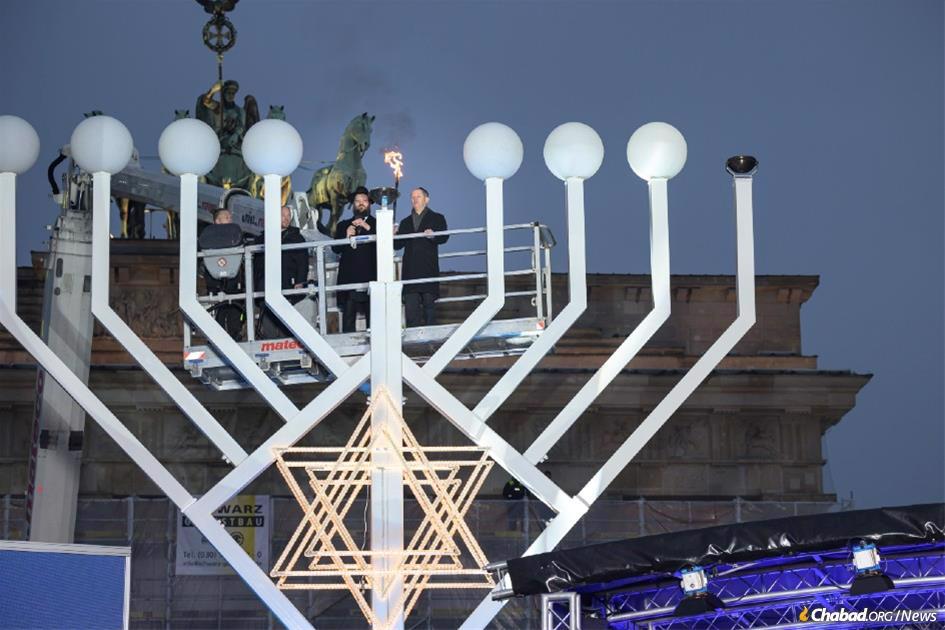 Germany’s Chancellor Olaf Scholz lights the menorah at the Brandenburg Gate with Chabad Rabbi Yehuda Teichtal of the Jewish community of Berlin. - Photo: Chabad of Berlin