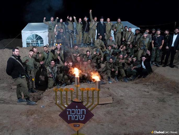 Soldiers at an IDF base celebrate the first night of Chanukah, along with Chabad-Lubavitch rabbis and student volunteers. - Photo: Chabad Youth Organization