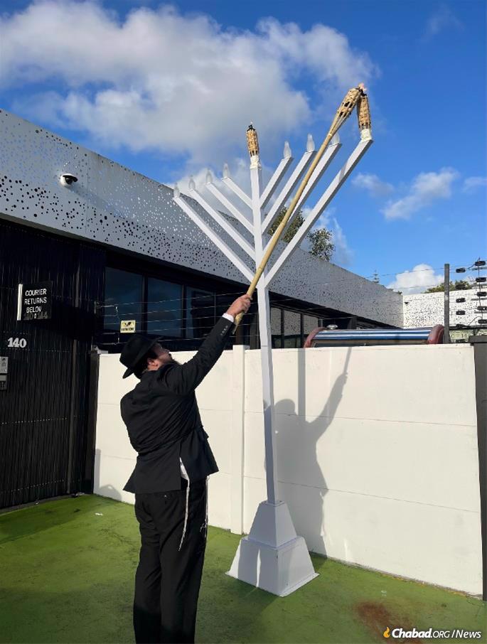 Rabbi Mendel Hecht lights the menorah in Auckland. - Photo: Chabad of New Zealand