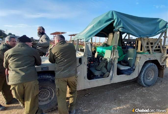 Sgt. Krugliak,sitting on jeep, a Chabad Chassid serving in Gaza with the mechanized transport division, helped get Morgenstern and the printer into Gaza.