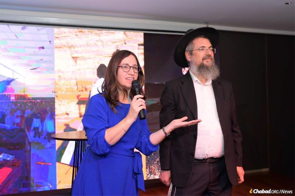 Chani Klein, co-director of Chabad of Eilat, adresses a gathering in her city in support of displaced Israelis, flanked by her husband, Rabbi Mendi Klein.