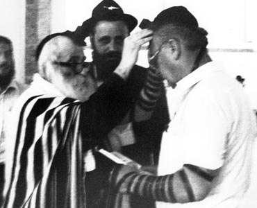 Noted Chabad chassid Rabbi Berke Chein puts on tefillin with MK Yitzhak Rabin during a visit to Kfar Chabad.