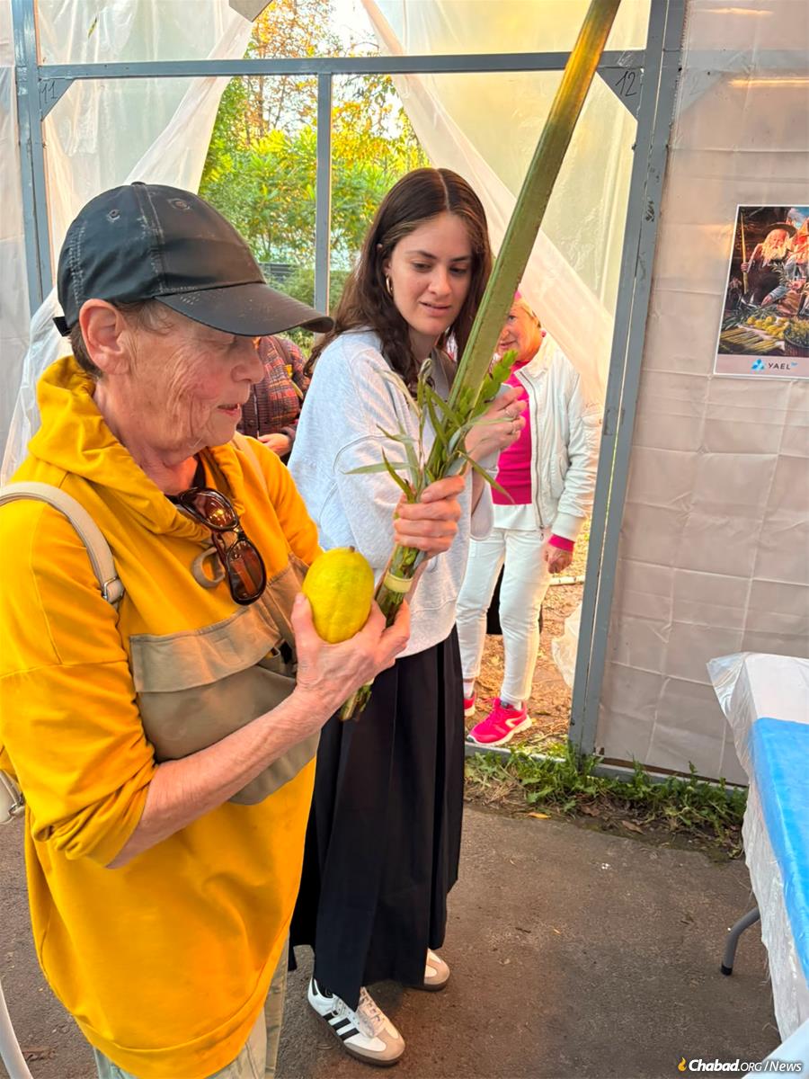 Rochel Kot helps a woman shake the Four Kinds during Sukkot in Gomel, Belarus.